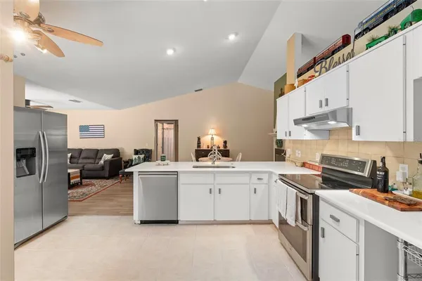 a kitchen with stainless steel appliances kitchen island granite countertop a refrigerator and a sink