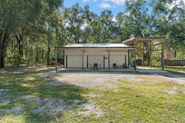 a view of a house with backyard and trees