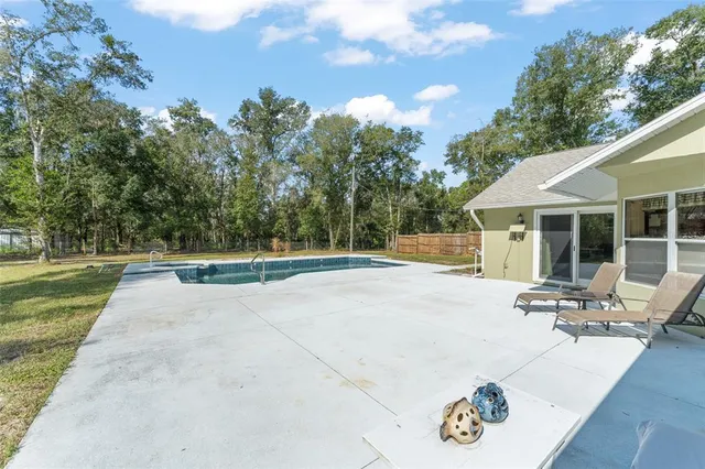 a backyard of a house with trees and outdoor seating
