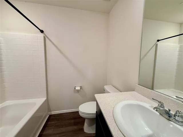 a white toilet sitting next to a bath tub