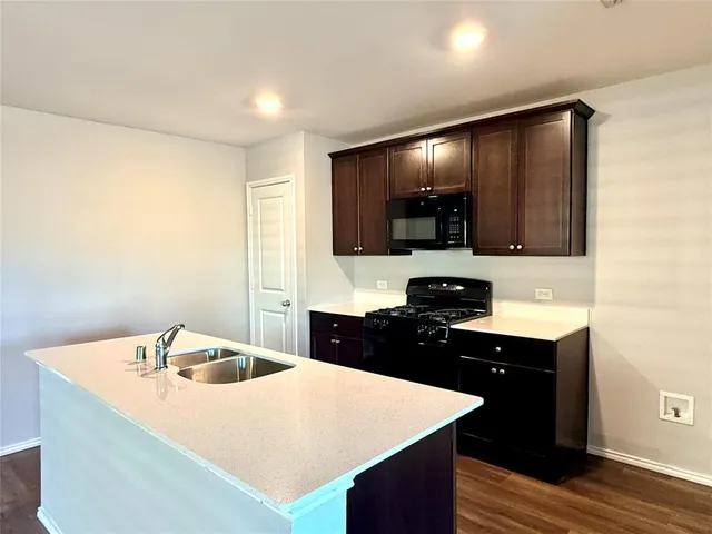 a kitchen with a sink a stove and cabinets