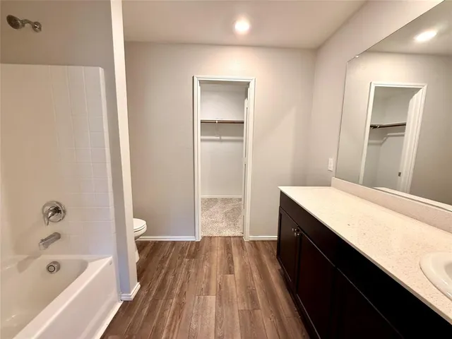 a bathroom with a tub sink and mirror