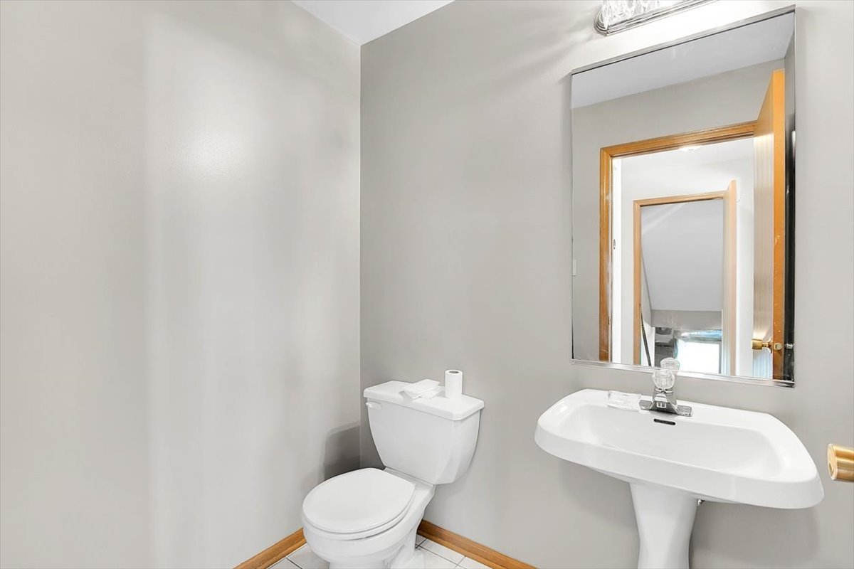 663 Primrose Lane Matteson, IL 60443 - Photo 22 of 32 a bathroom with a toilet a sink and mirror
