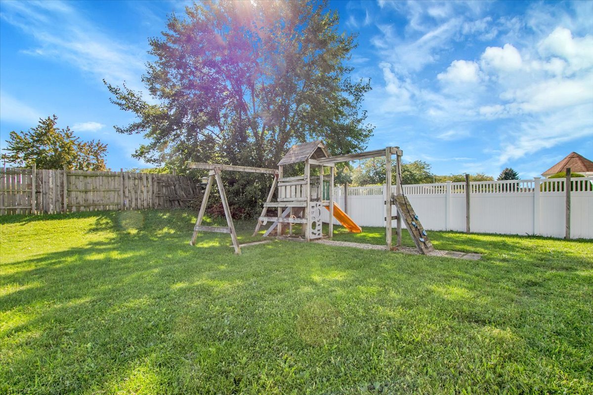 663 Primrose Lane Matteson, IL 60443 - Photo 25 of 32 a view of a backyard with a slide trees and wooden fence
