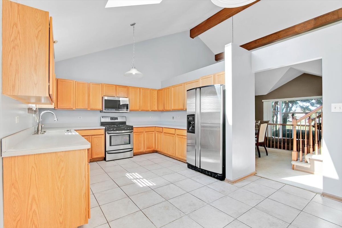 663 Primrose Lane Matteson, IL 60443 - Photo 7 of 32 a large kitchen with stainless steel appliances granite countertop a sink and a refrigerator