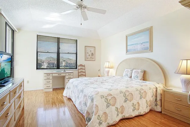 a bedroom with a large bed and a flat tv screen on dresser