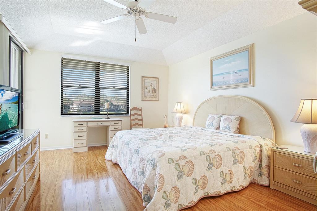 6081 Southeast Landing Way, Unit 9 Stuart, FL 34997 - Photo 13 of 31 a bedroom with a large bed and a flat tv screen on dresser