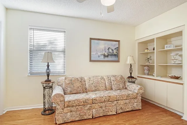 a living room with furniture a window and a wooden floor