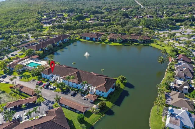 an aerial view of lake and residential houses with outdoor space