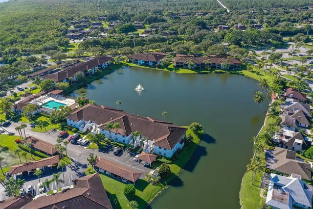 an aerial view of lake and residential houses with outdoor space