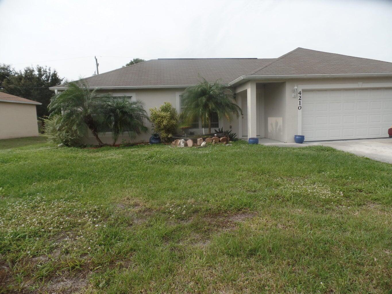 4210 Southwest Utterback Street Port St. Lucie, FL 34953 - Photo 1 of 7 a view of a house with backyard and garden