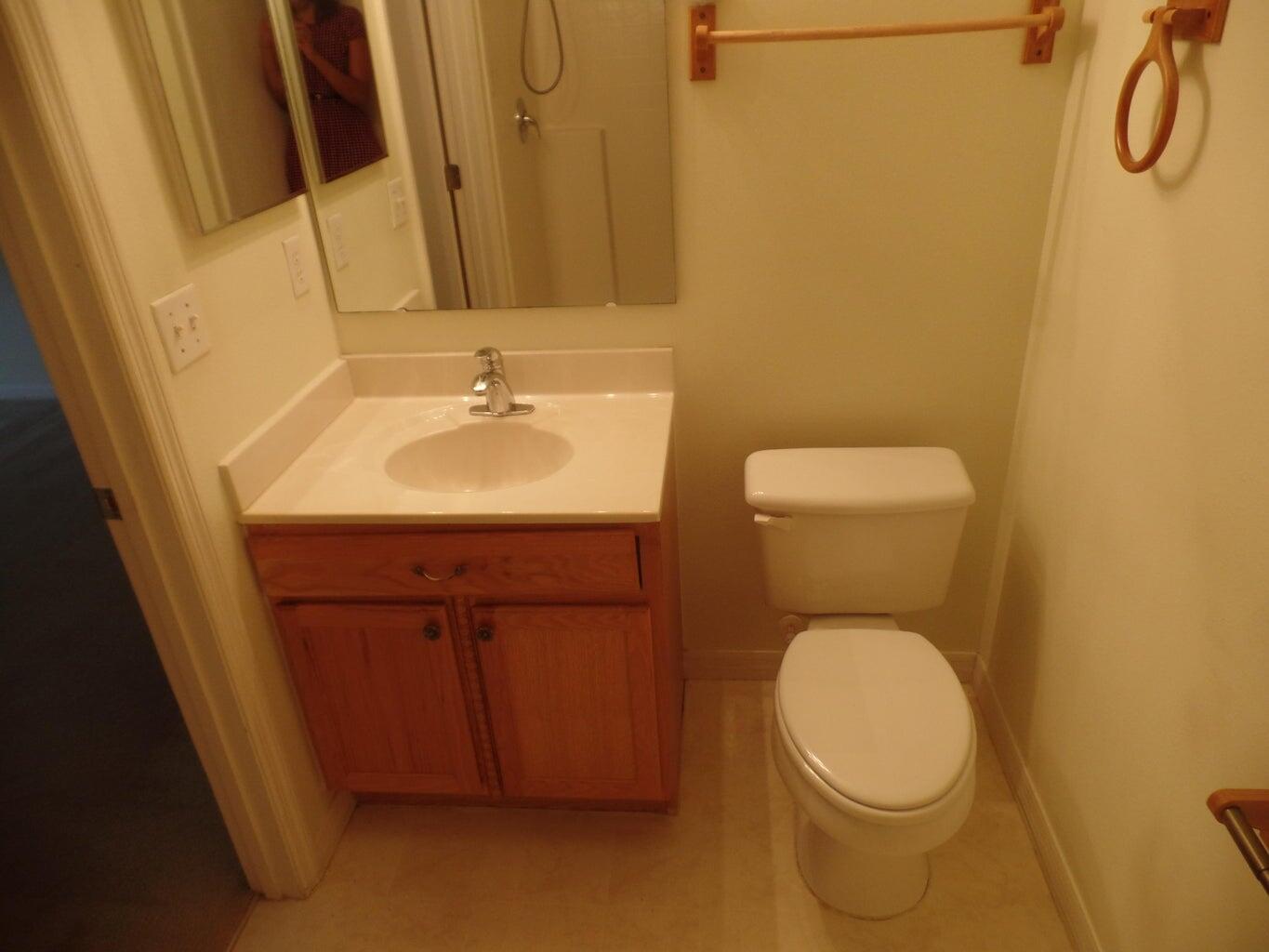 4210 Southwest Utterback Street Port St. Lucie, FL 34953 - Photo 5 of 7 a bathroom with a toilet sink and mirror