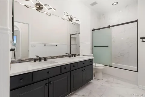 a bathroom with a double vanity sink mirror and toilet