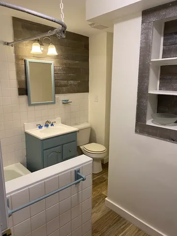 a bathroom with a sink a toilet and mirror