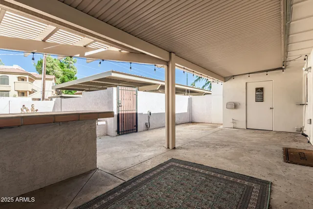 a view of a porch with a table and chairs under an umbrella