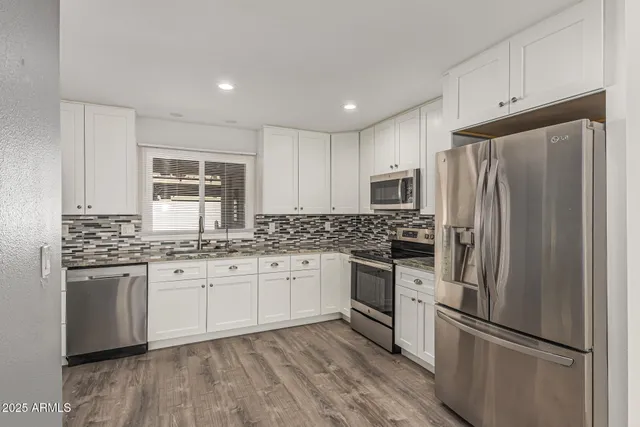 a kitchen with stainless steel appliances granite countertop a stove a refrigerator and a sink