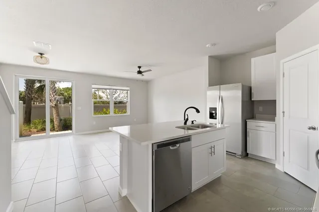 a kitchen with stainless steel appliances granite countertop a sink and a refrigerator