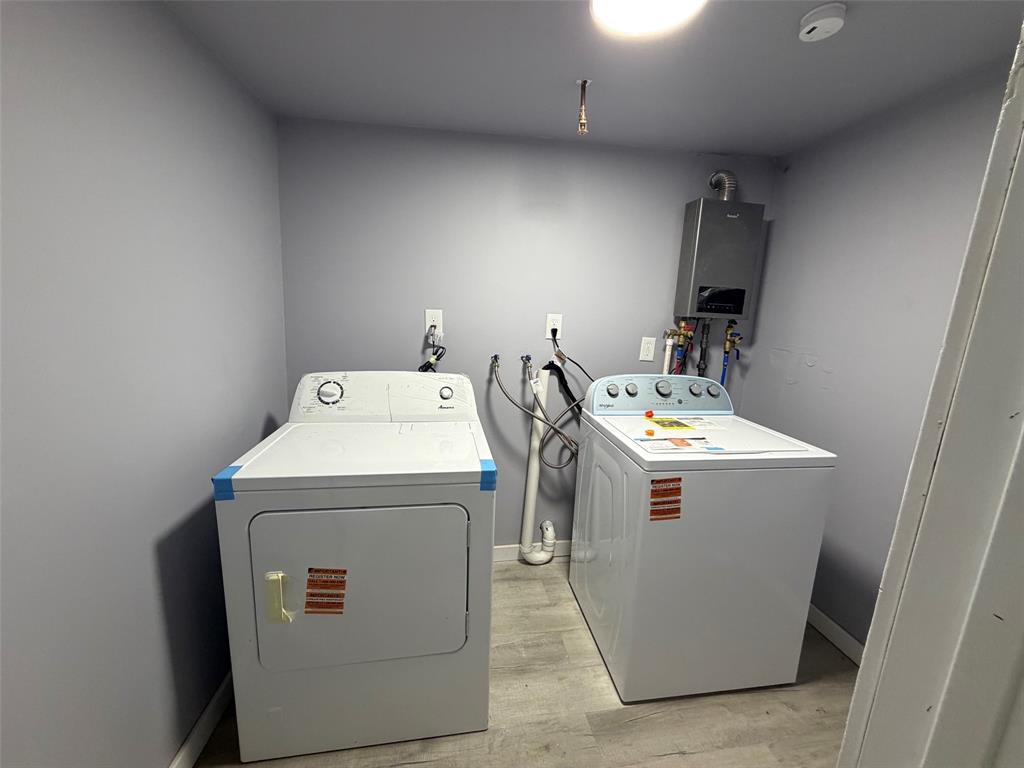 714 Southwest Dallas Street Grand Prairie, TX 75051 - Photo 25 of 27 Dedicated laundry area featuring a light gray painted wall finish and wood-finish flooring
