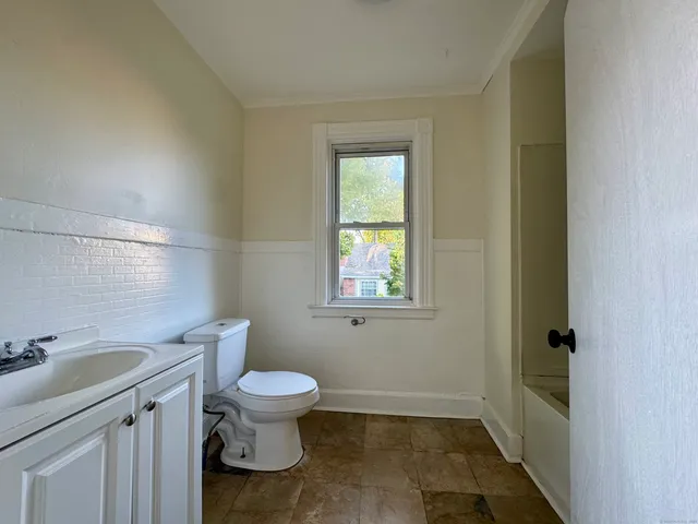 a bathroom with a toilet a sink and a window