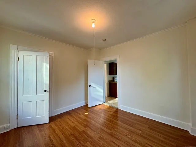 a view of an empty room with wooden floor
