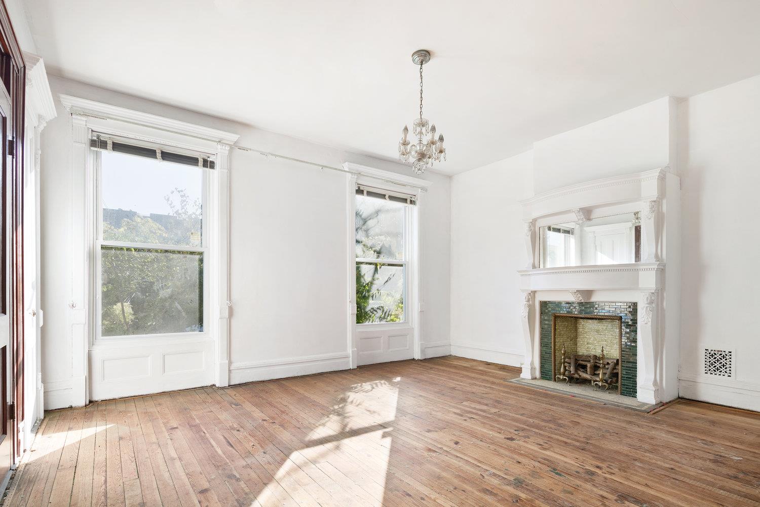 a view of a livingroom with wooden floor fireplace and windows
