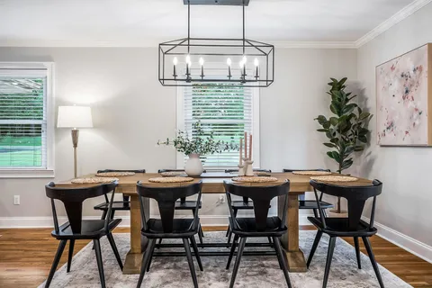 a dining room with furniture a potted plant and a chandelier