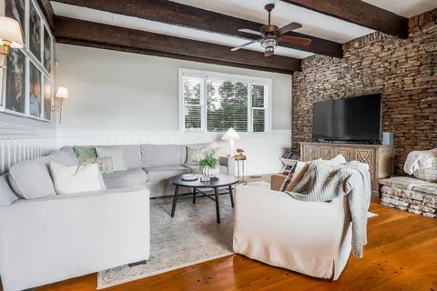 a spacious bedroom with a bed and wooden floor