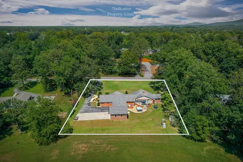 an aerial view of a house with a yard basket ball court and outdoor seating