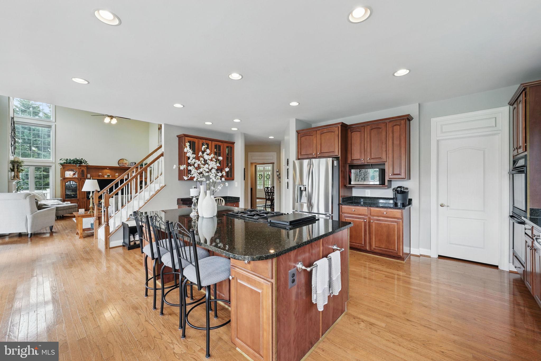 40755 Lenah Run Circle Aldie, VA 20105 - Photo 7 of 37 a kitchen with stainless steel appliances kitchen island granite countertop a table chairs refrigerator and a sink