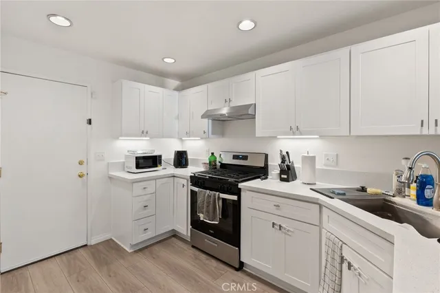 a kitchen with white cabinets stainless steel appliances and sink