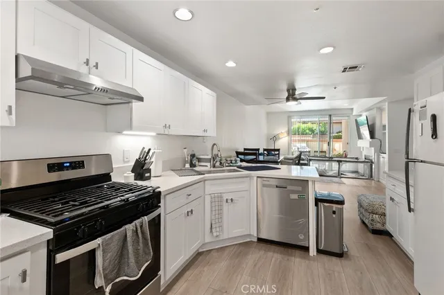 a kitchen with white cabinets and appliances