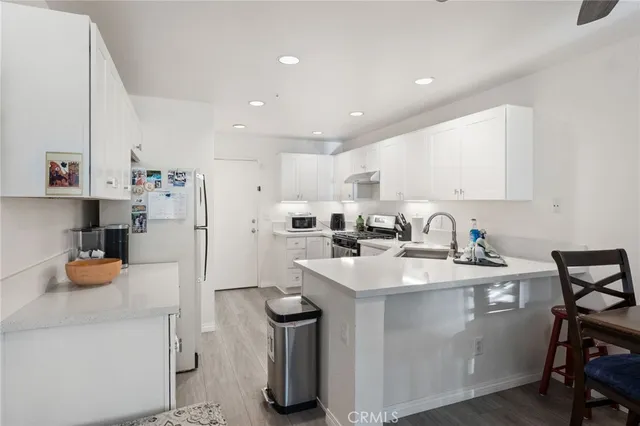 a kitchen with a sink a stove a refrigerator and cabinets