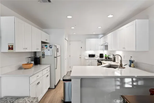 a kitchen with white cabinets and refrigerator