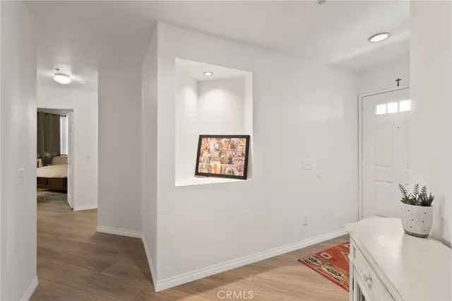 a view of a hallway with wooden floor and a bathroom