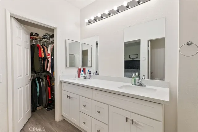 a bathroom with a double vanity sink a mirror and a shower