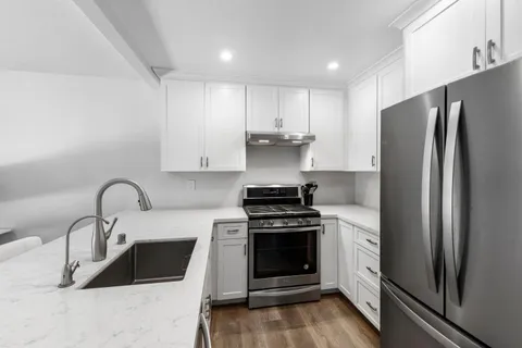 a kitchen with stainless steel appliances granite countertop a sink stove and refrigerator