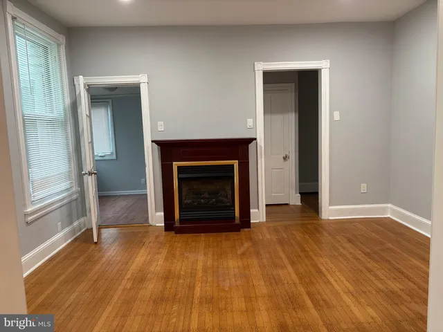 a view of an empty room with a fireplace and a window