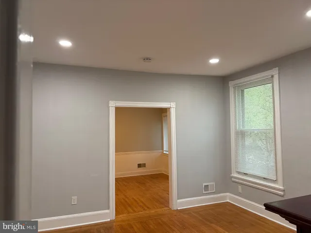 an empty room with wooden floor and a window