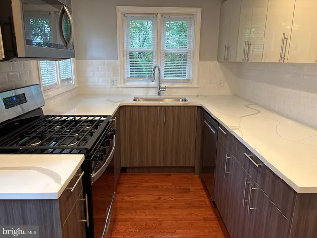 a kitchen with granite countertop a stove a sink and a counter