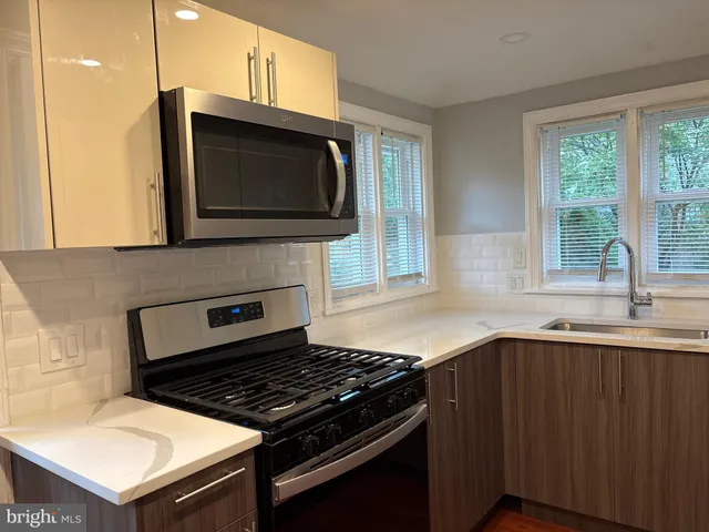 a kitchen with stainless steel appliances a stove sink and microwave