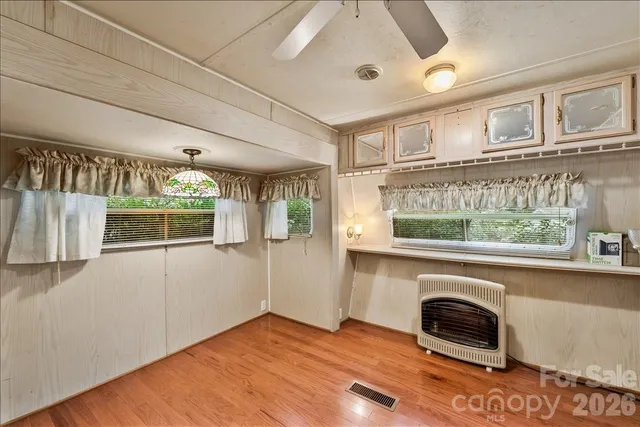 a kitchen with stainless steel appliances a stove a refrigerator a sink a oven with wooden cabinets and floor