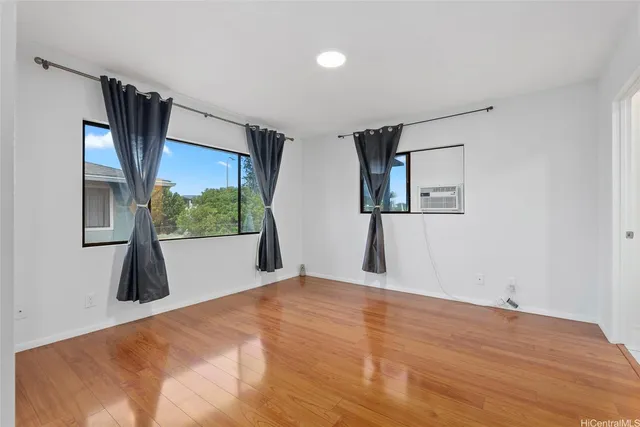 a view of a bedroom with wooden floor and a window
