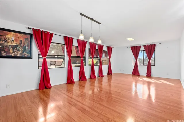 a view of empty room with wooden floor