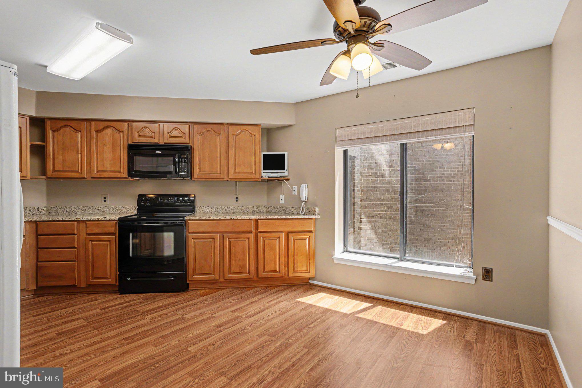 3021 Fallstaff Road, Unit 208B Baltimore, MD 21209 - Photo 13 of 25 a kitchen with stainless steel appliances granite countertop a stove a sink and a microwave