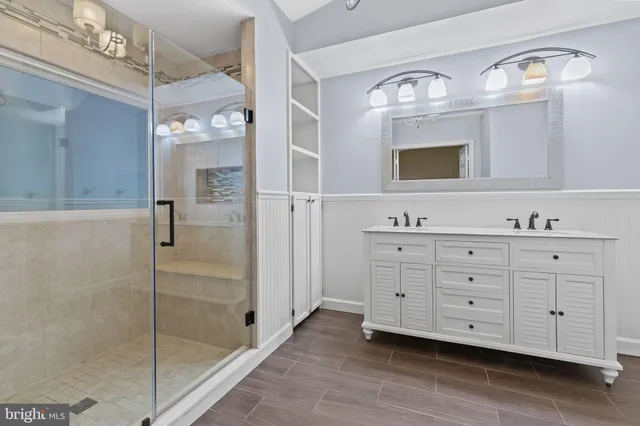 a bathroom with a double vanity sink mirror and shower