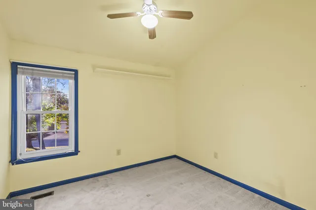 a view of a room with a window and a ceiling fan
