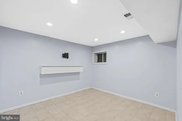 an empty room with windows and cabinet