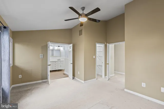 a view of an empty room with a ceiling fan