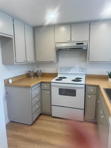 a kitchen with stainless steel appliances granite countertop a stove a sink and a white cabinets
