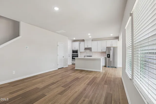 a view of a kitchen with a sink and dishwasher with wooden floor